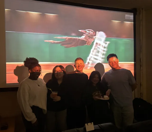 5 people standing in front of a projector screen.
