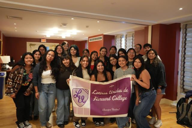 A group of students holding a Latinas Unidas de Harvard College banner. 
