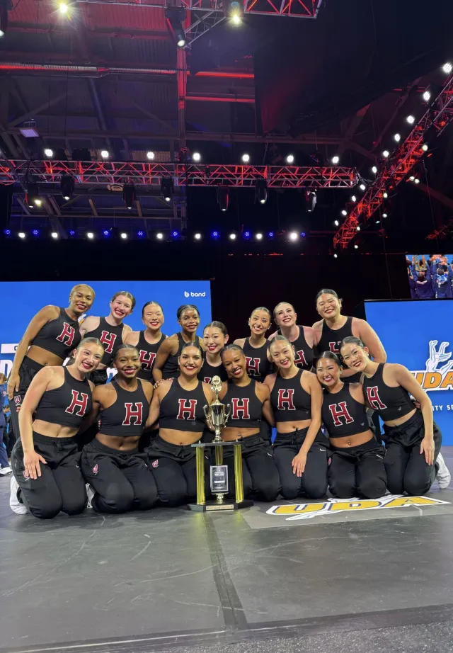 The Dance Team onstage crowded around their trophy.
