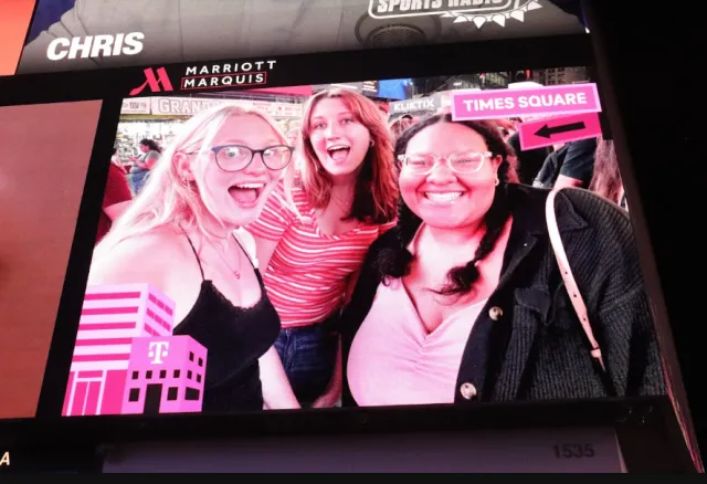 Three friends on a billboard in times square. 