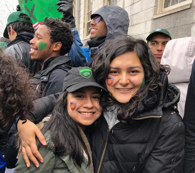 Maria posing with one of her friends who also lives in Currier. They are outside and it is snowing. 