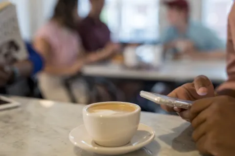 Student using phone at a coffee shop