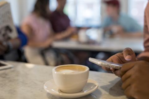 Student using phone at a coffee shop