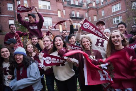 Students cheering with Harvard gear