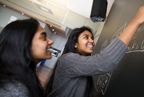 students at chalk board working on math