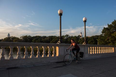 Student biking across bridge