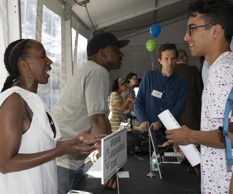 students at a table outside at an advising fair on campus