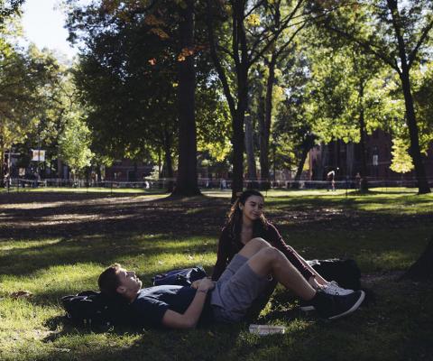 Two students sit In Harvard Yard.