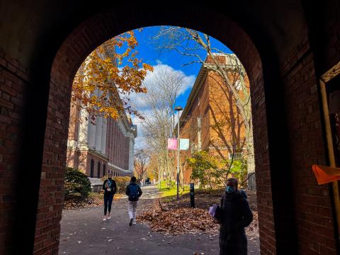 Students walking through the gated entrance to Harvard Yard.