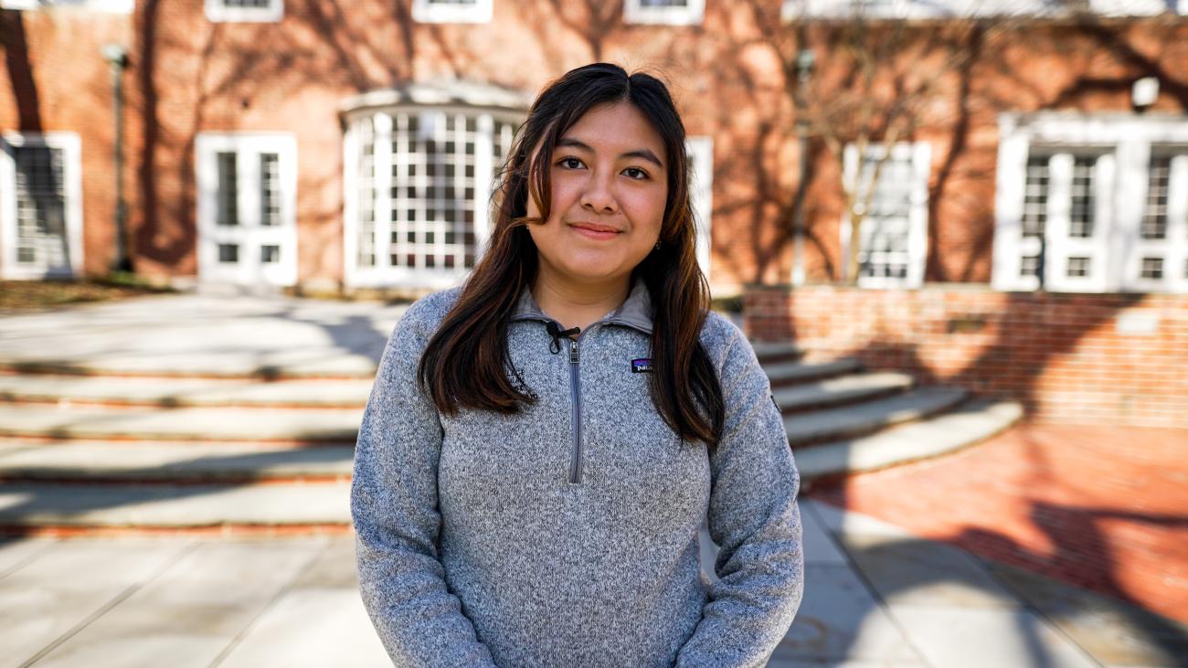 Harvard student standing in a courtyard.