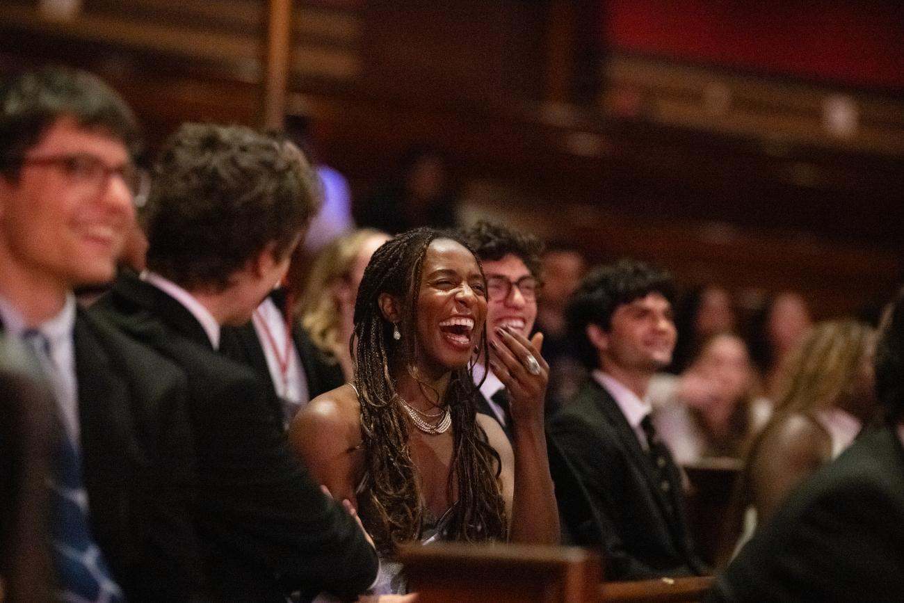 A female student laughing in the audience.