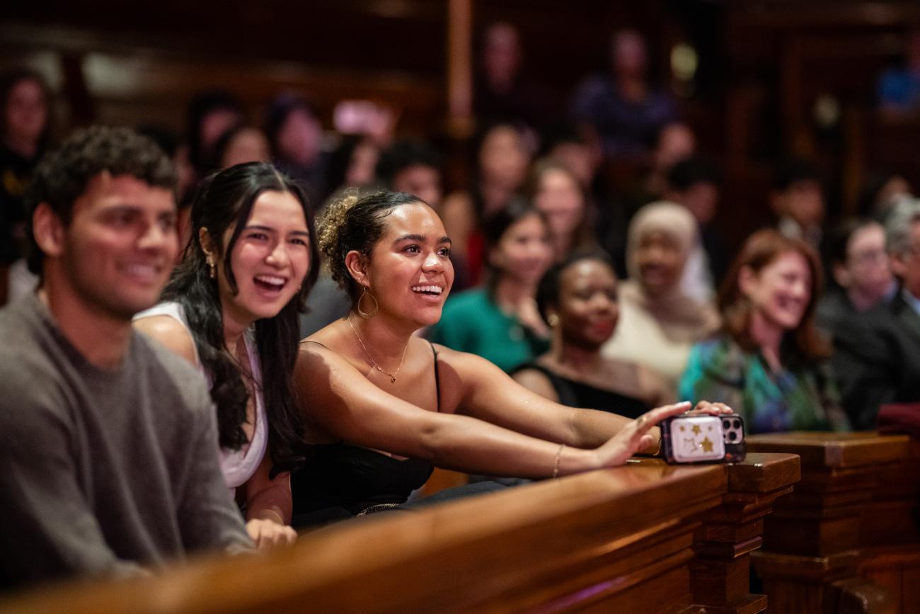 A student in the audience holding out her phone to tape part of the show.