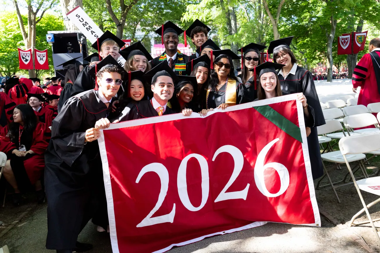 The Summas holding up a big red 2026 banner and smiling for a photo together.
