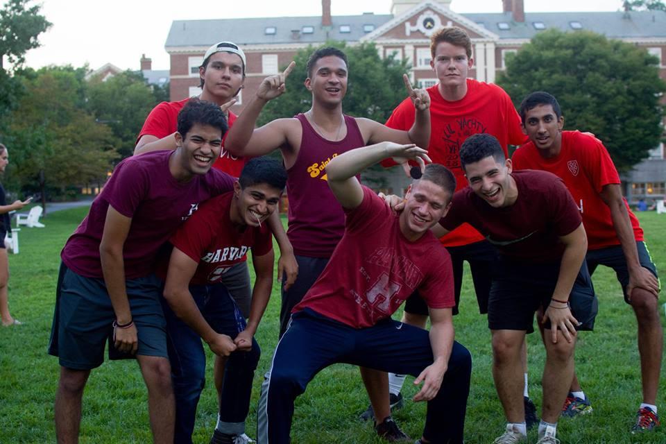 students pose in group to celebrate victory on field with team