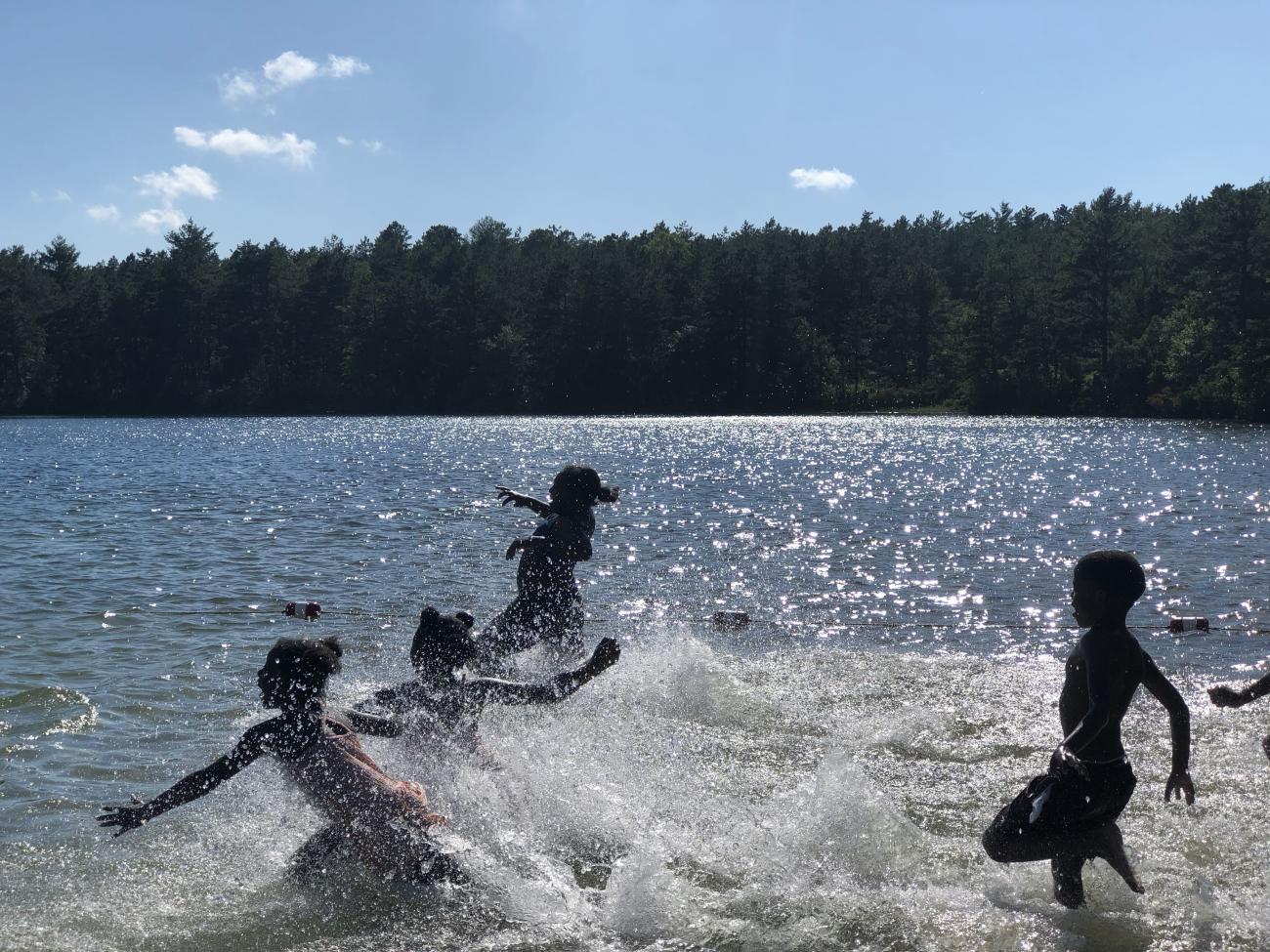 Kids running into the water at the lake