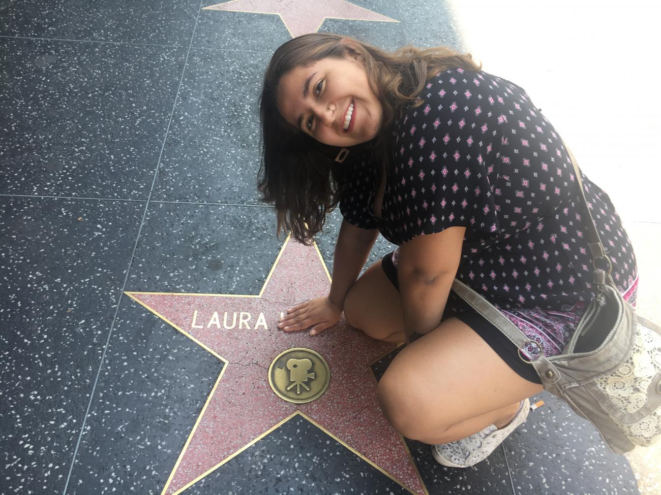student sitting on the Hollywood Walk of Fame