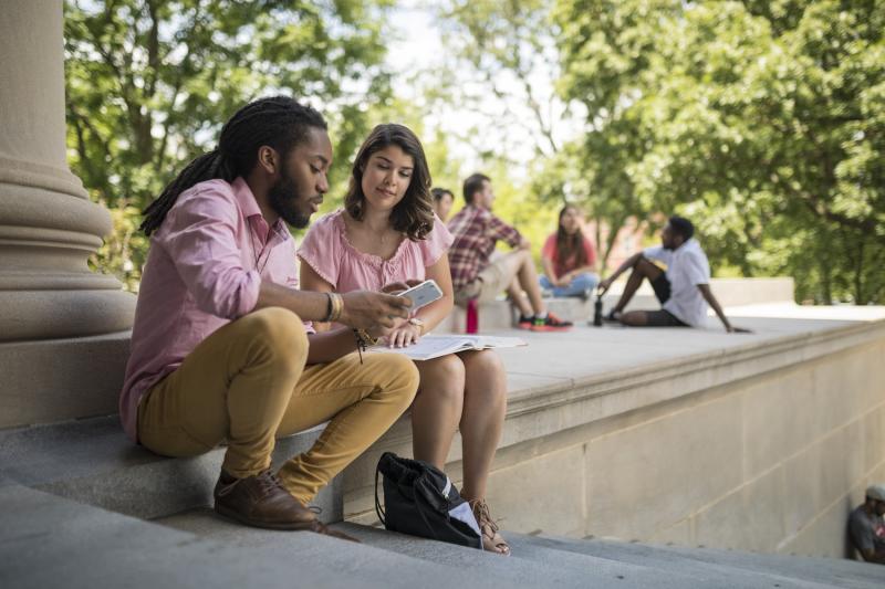 Two students looking at a cell phone