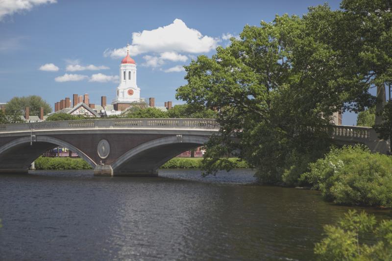 View of a bridge over the Charles river. Harvard campus can be seen in the background.