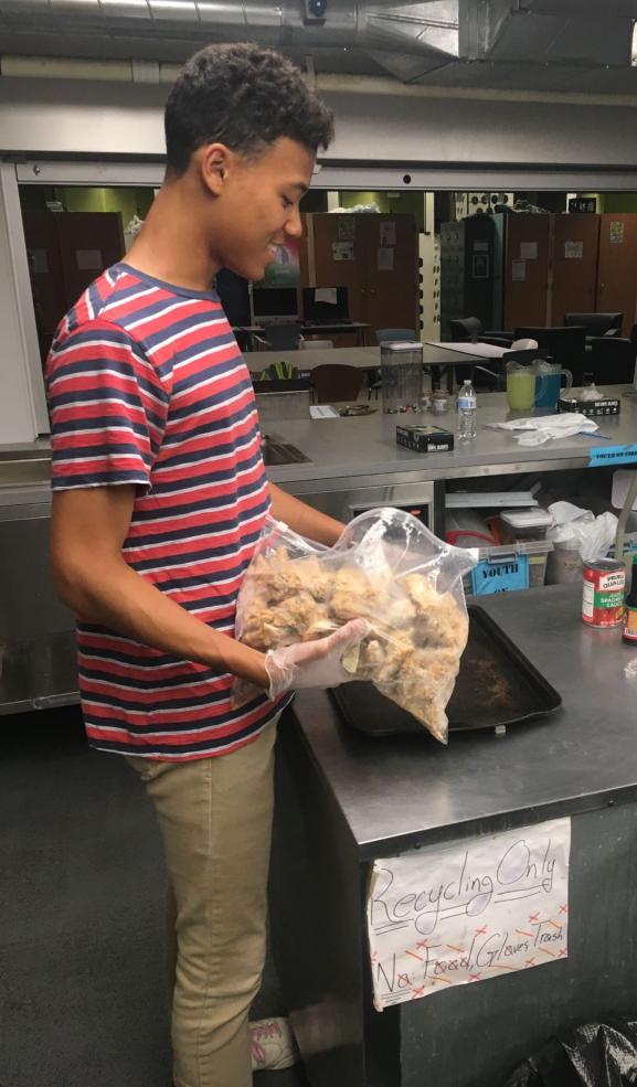 Student putting food on pan.