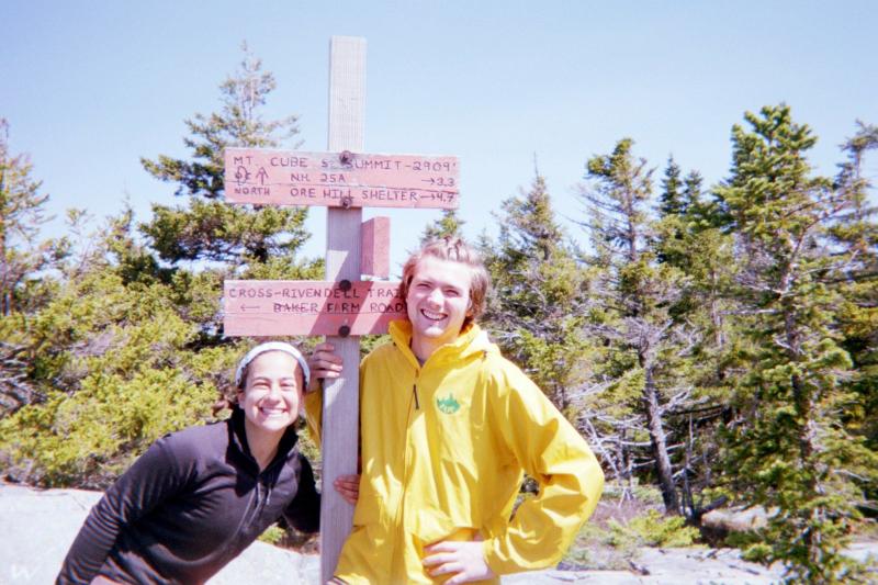 Two people in front of hiking sign