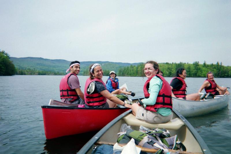 Hiking group canoeing on a body of water