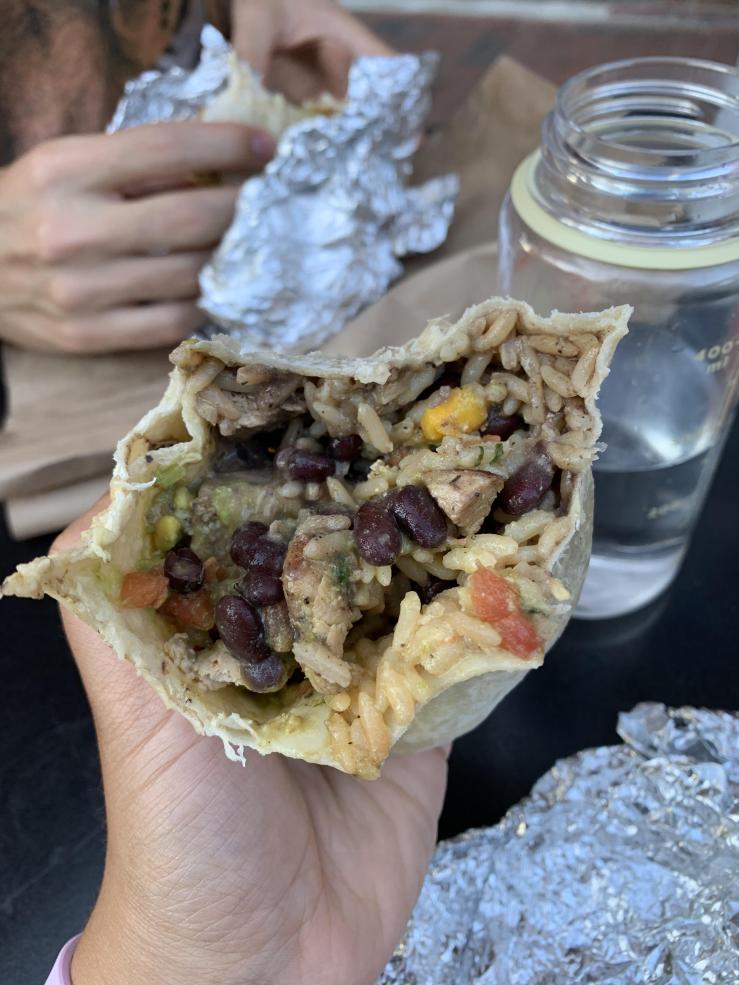 Two students each holding a burrito from El Jefe's Taqueria