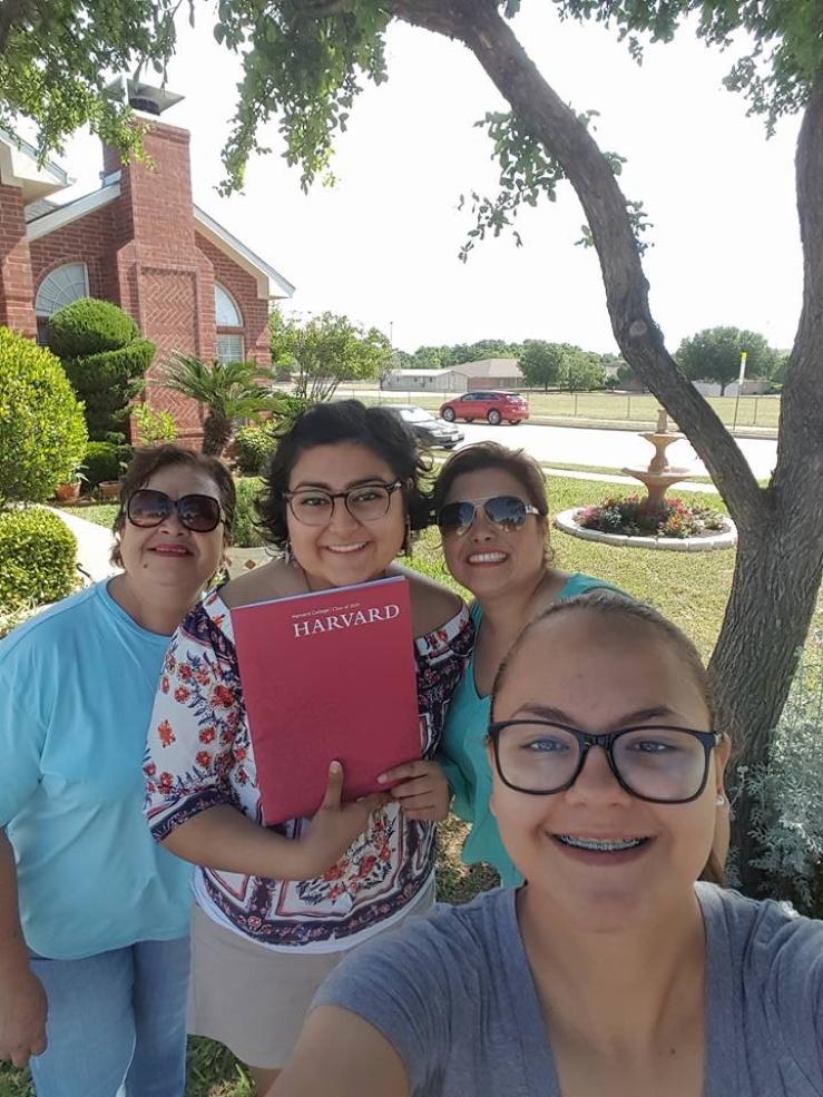 Maria posing with her family with her Harvard acceptance.