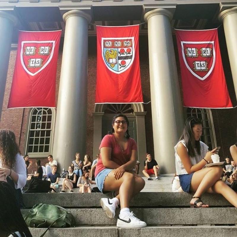 Maria posing on the steps with the Harvard banners. 