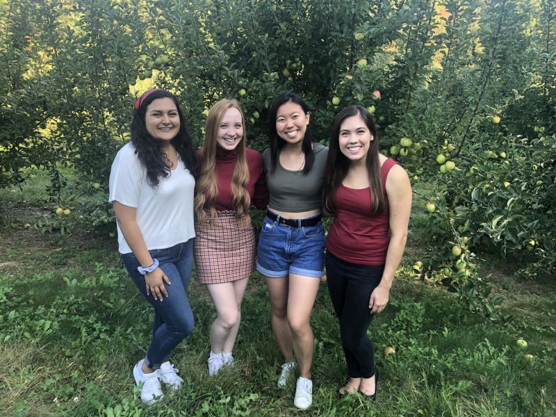 Maria and her friends posing in an apple orchard.