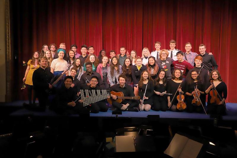 A large group of people on a stage posing for a photo