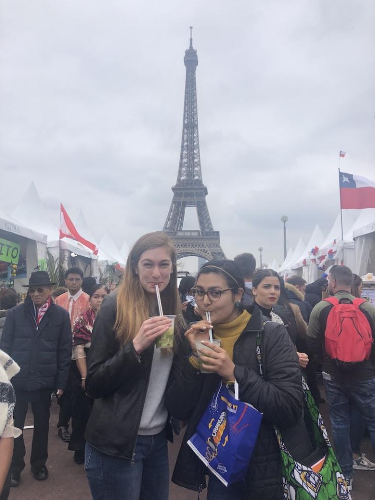 Maria posing with a friend in front of the Eiffel Tower. 