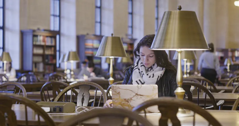 Student studying on laptop in library