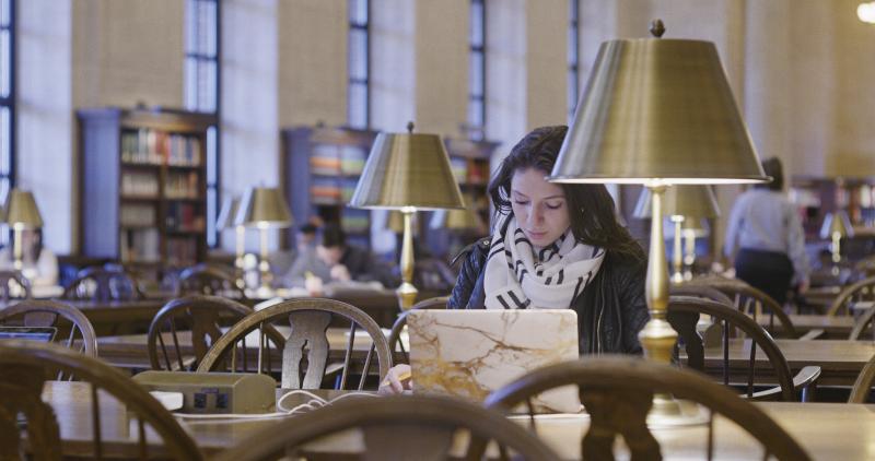 Student studying on laptop in library