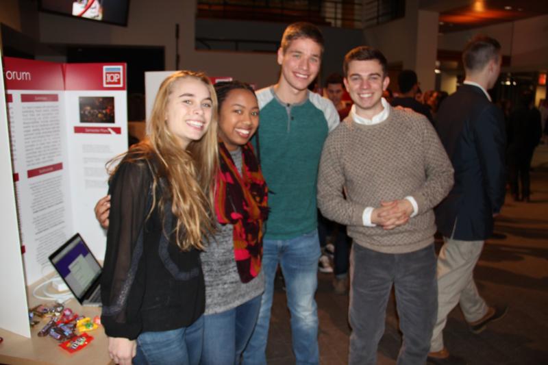 Four students posing in front of presentation booth