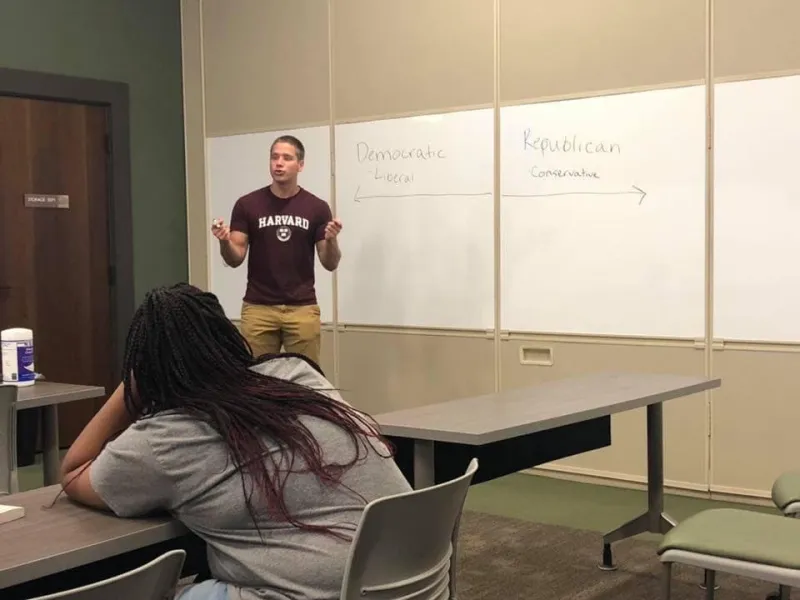Student presenting in front of white board