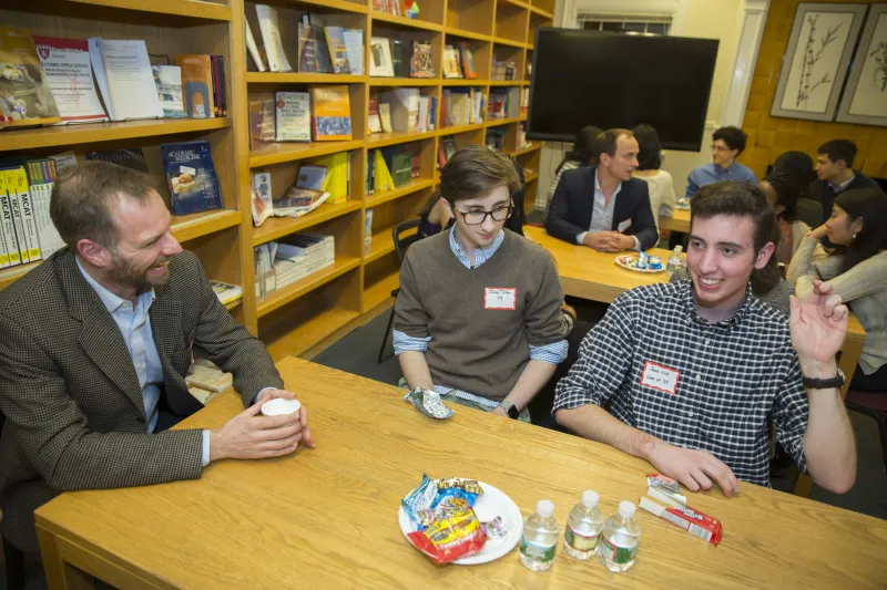 Music professor, Alex Rehding, (from left) talks with Jake Tilton '19 and Jacob Link '19 inside the Office for Career Services during a dinner with arts and humanities faculty and students.