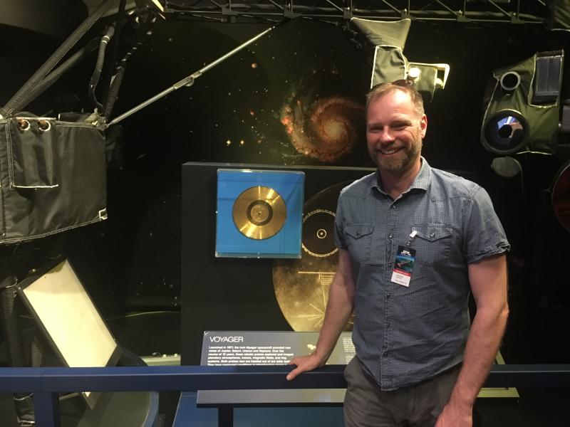 Professor Alexander Rehding stands next to the Golden Record, the subject of his General Education Course "Music from Earth."