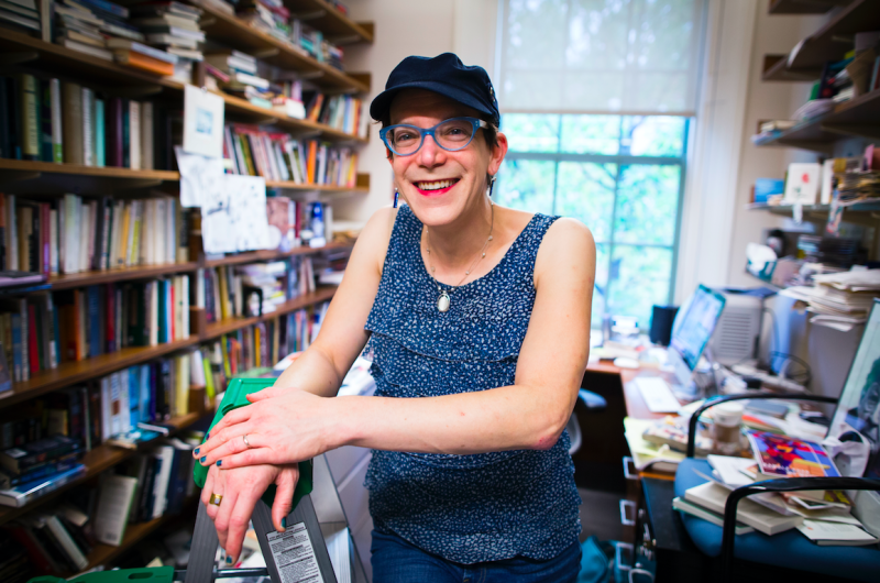 Professor Stephanie Burt poses in her office, surrounded by books.