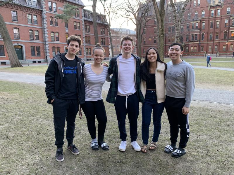 Five Harvard students posing for a picture in Harvard Yard before leaving