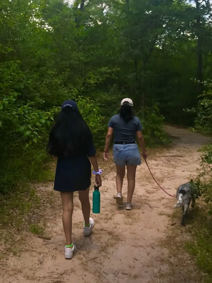 Two girls hiking along a path.