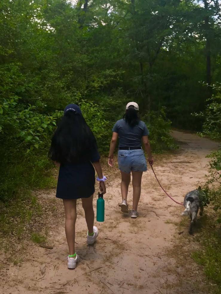 Two girls hiking along a path.