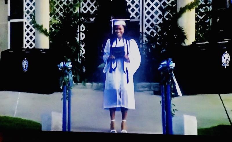 This is a picture of me taking a picture with my diploma at graduation.