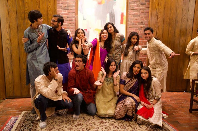 Group of smiling students indoors wearing festive Indian clothes