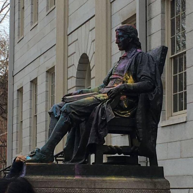 Statue of John Harvard lightly dusted with colored powder