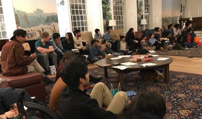 A group of college students sitting on the floor in a circle