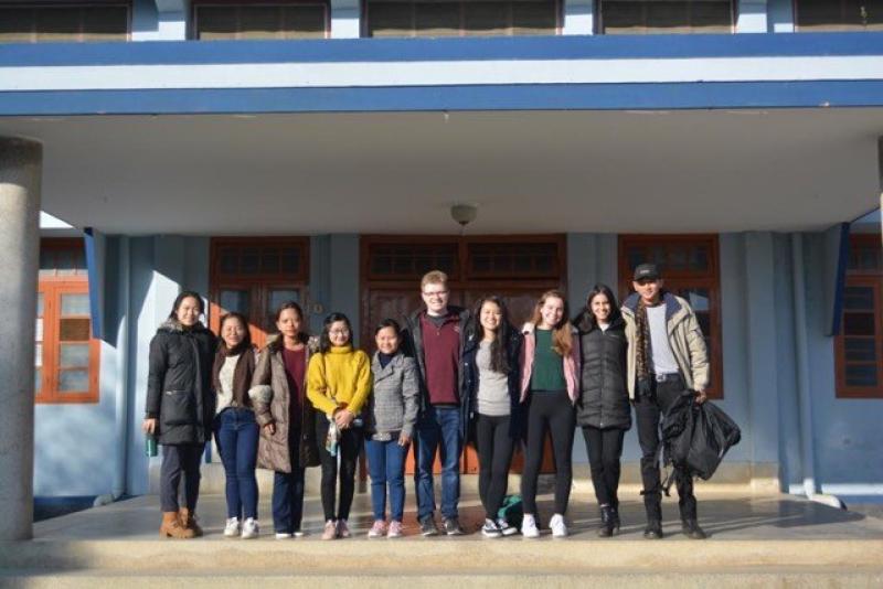 Group of students standing in front of a school building in India