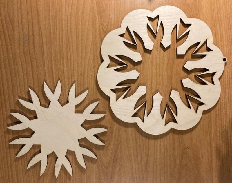 Two woodcut designs in the shape of snowflakes