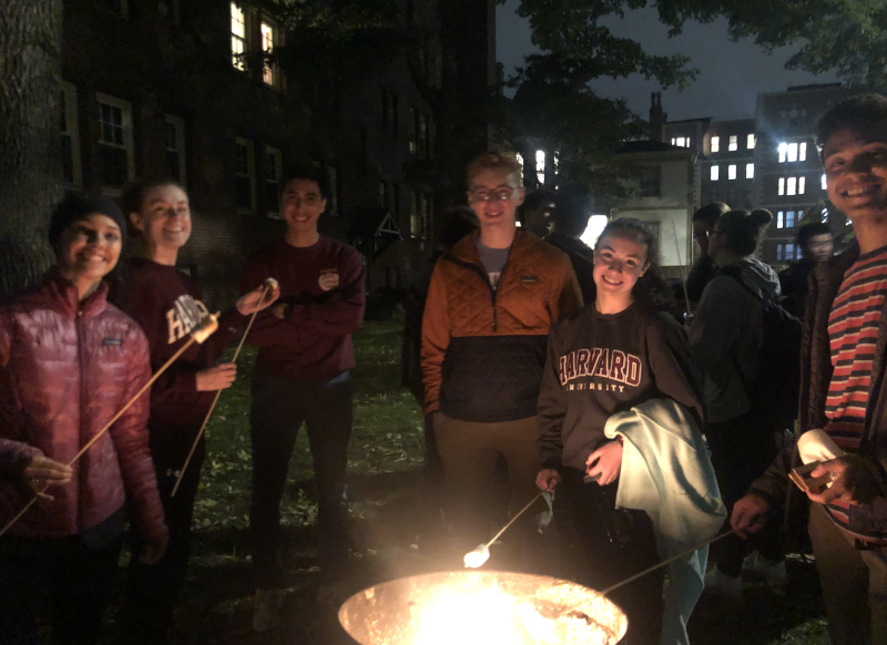 Students roasting marshmallows around a fire