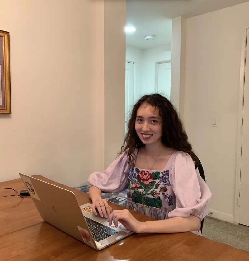 Alian pressing submit on laptop at kitchen table 