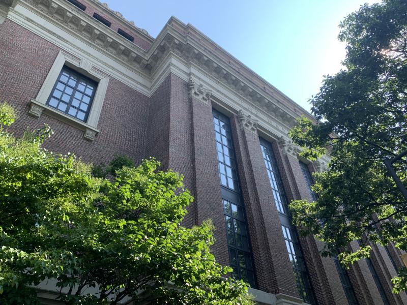 The back of Widener Library on a sunny day surrounded by trees